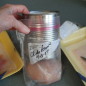 A large can being used to fill a freezer bag.