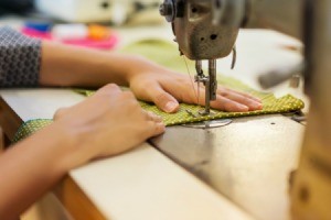 Using a sewing machine to sew using a tablecloth as fabric.