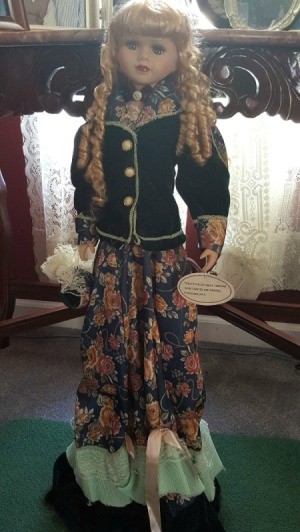 Value of Porcelain Doll - blond doll with ringlets, wearing long floral skirt and buttoned jacket