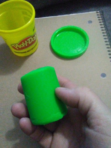 Mod Podge to Preserve Play Doh Creations - hand holding a piece of green Play Doh