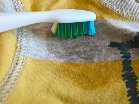 White Vinegar for Removing Sticker Residue from Clothing - remove paper and work the vinegar into the shirt using a toothbrush