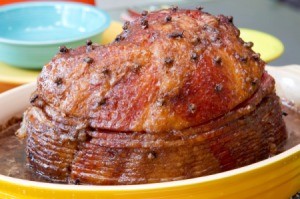 A browned spiral sliced ham in a baking dish.