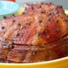 A browned spiral sliced ham in a baking dish.