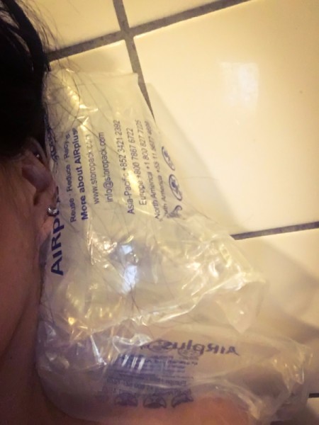 Plastic packaging being used as a bath pillow.