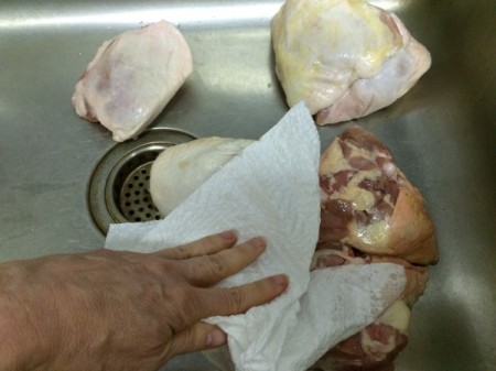 cleaning and drying chicken in sink