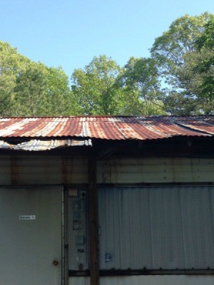 Inexpensive Roof Replacement for Low Income Homeowner - rusted tin roof on old mobile home