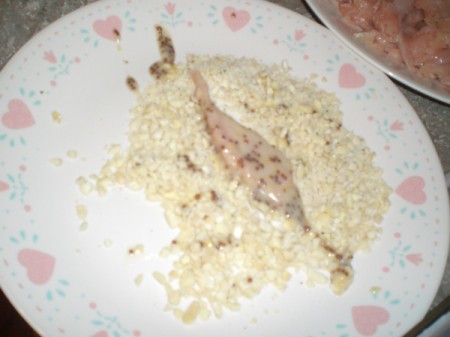 rolling marinated chicken in ground nuts