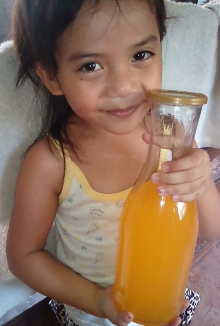 A child holding a glass bottle of juice.