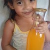 A child holding a glass bottle of juice.