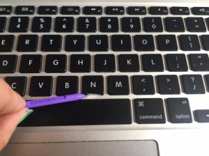 Cleaning a laptop keyboard with an interdental brush.