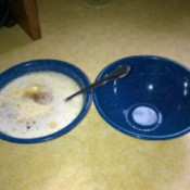 A bowl filled with food next to another empty bowl.