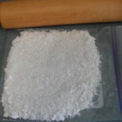 A plastic bag of crushed egg shells and a rolling pin.