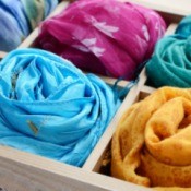 Several colorful silk scarves in a divided box.