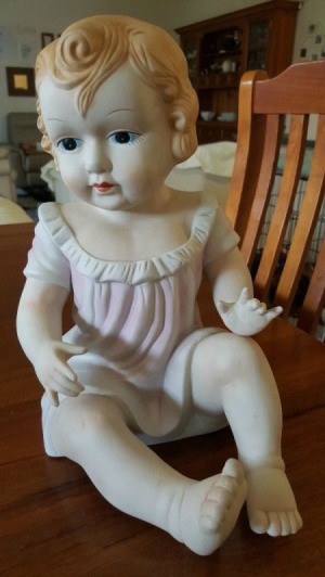 Information on Bisque Doll - ceramic baby doll wearing a pink dress