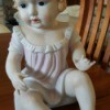 Information on Bisque Doll - ceramic baby doll wearing a pink dress