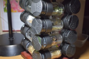 A spice rack being used to organize seeds.