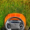 A riding lawnmower, from the view of the seat.