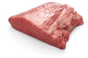 An uncooked beef brisket on a white background.
