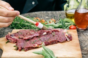 Brushing marinade on a piece of meat.