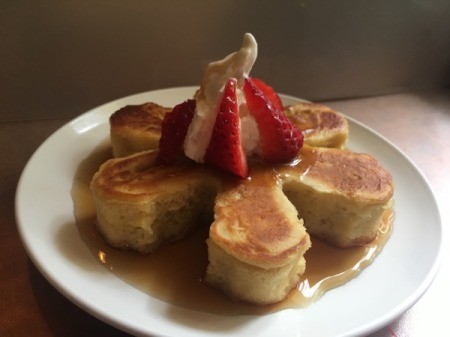 Japanese Style Puff Pancakes on plate with fruit, syrup and whipped cream