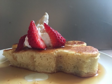 Japanese Style Puff Pancakes on plate with fruit, syrup and whipped cream