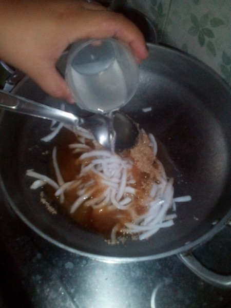 water added to thin strips of coconut and sugar in pan