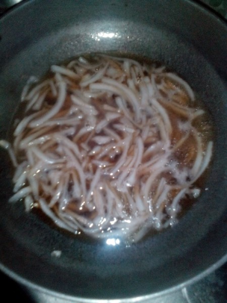 water added to thin strips of coconut and sugar in pan