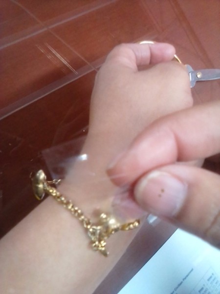 A bracelet taped on to the wrist to help with hooking the clasp.