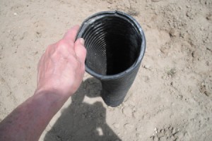 A long pipe pointing to the ground, for use in planting seeds.