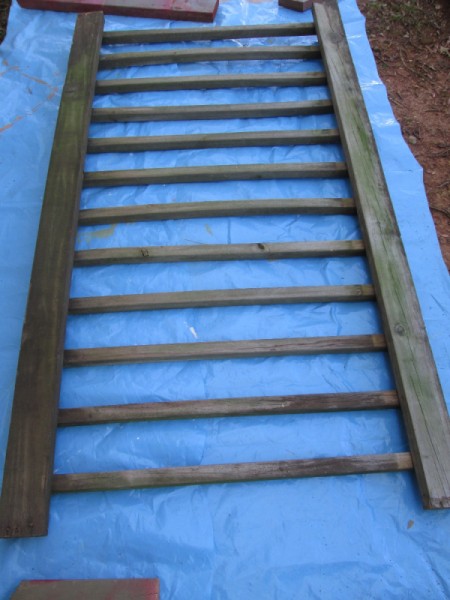 Old Deck Railing Used For Garden Tool Storage - railing on blue tarp ready for painting
