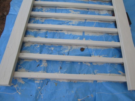 Old Deck Railing Used For Garden Tool Storage - painted railing on blue tarp