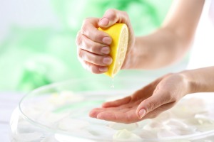 A woman squeezing lemon juice into her hand.