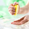 A woman squeezing lemon juice into her hand.