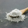 A white powder on a spoon, either baking soda or baking powder.