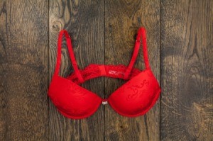 A red bra on a wooden background.