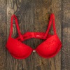 A red bra on a wooden background.