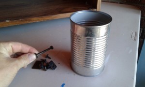 A recycled aluminum can for storing nails and other hardware.