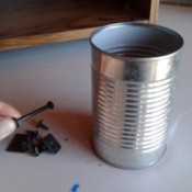 A recycled aluminum can for storing nails and other hardware.