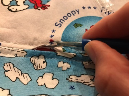 Book Pocket Pillow - Turn the pillow over and use a seam ripper to carefully open up the seam where the zipper is. DO NOT unstitch the first and last inch.