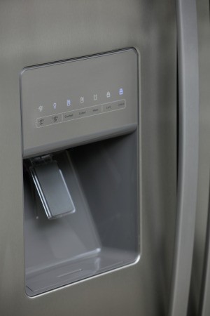 An icemaker on the door of a refrigerator.