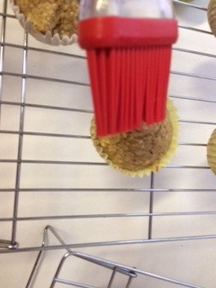 brushing cooked muffins with butter