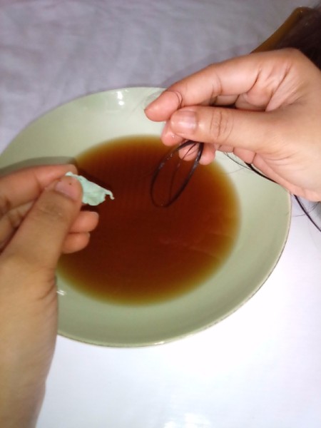 A piece of gum that is being removed from a child's hair.