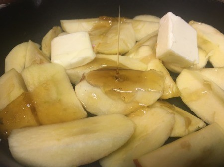 adding honey to apple slices