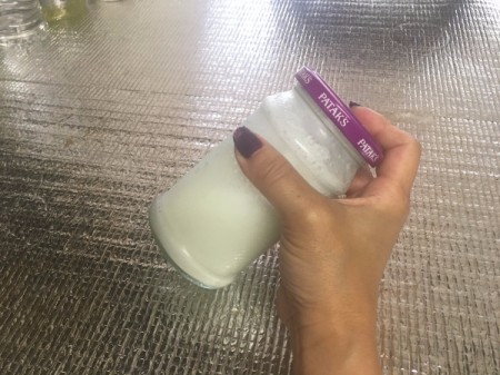 Frothing milk in a glass jar.