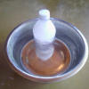 A frozen water bottle in a pet's water bowl.