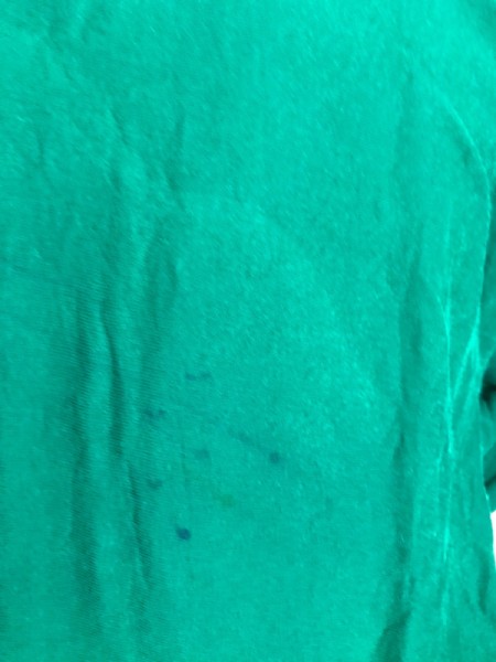 A green sweatshirt with permanent marker pen drawn on the back.