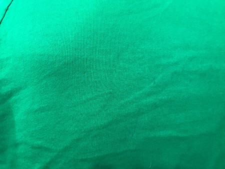 A green sweatshirt with very faded pen markings.