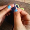 A repaired shoelace being inserted into the eyelet of a pair of shoes.