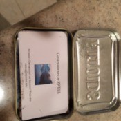 An Altoids mint container holding business cards.