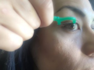Woman using dental floss to apply eyeliner